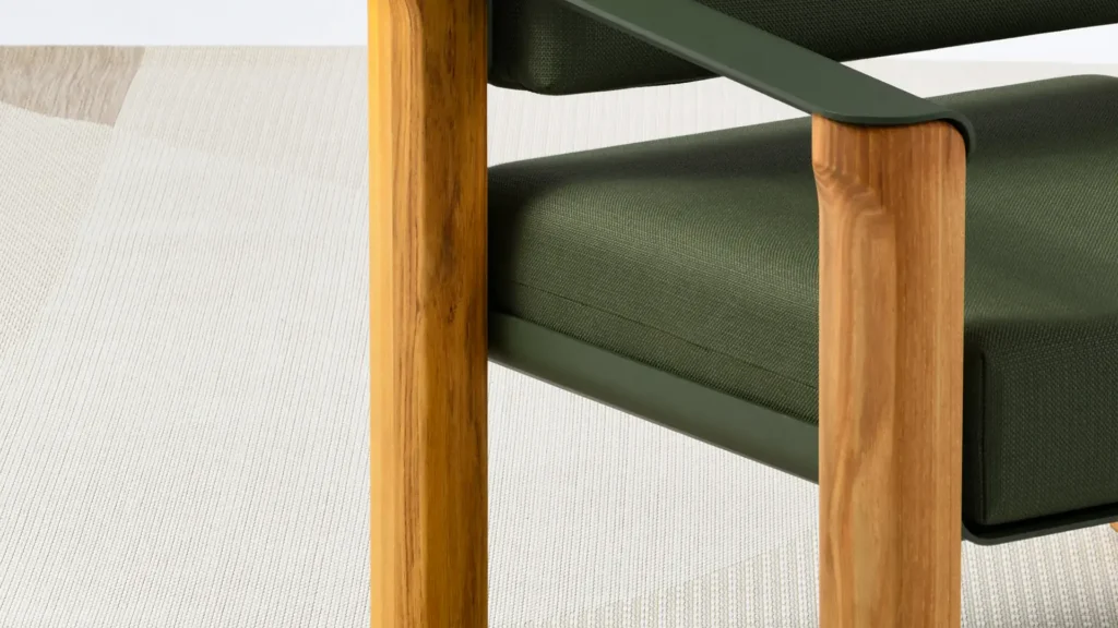 Gros plan sur les pieds en bois clair et l'assise en tissu vert kaki d'un fauteuil.